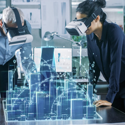 Male and Female Architects Wearing  Augmented Reality Headsets Work with 3D City Model. High Tech Office Professional People Use Virtual Reality Modeling Software Application.
